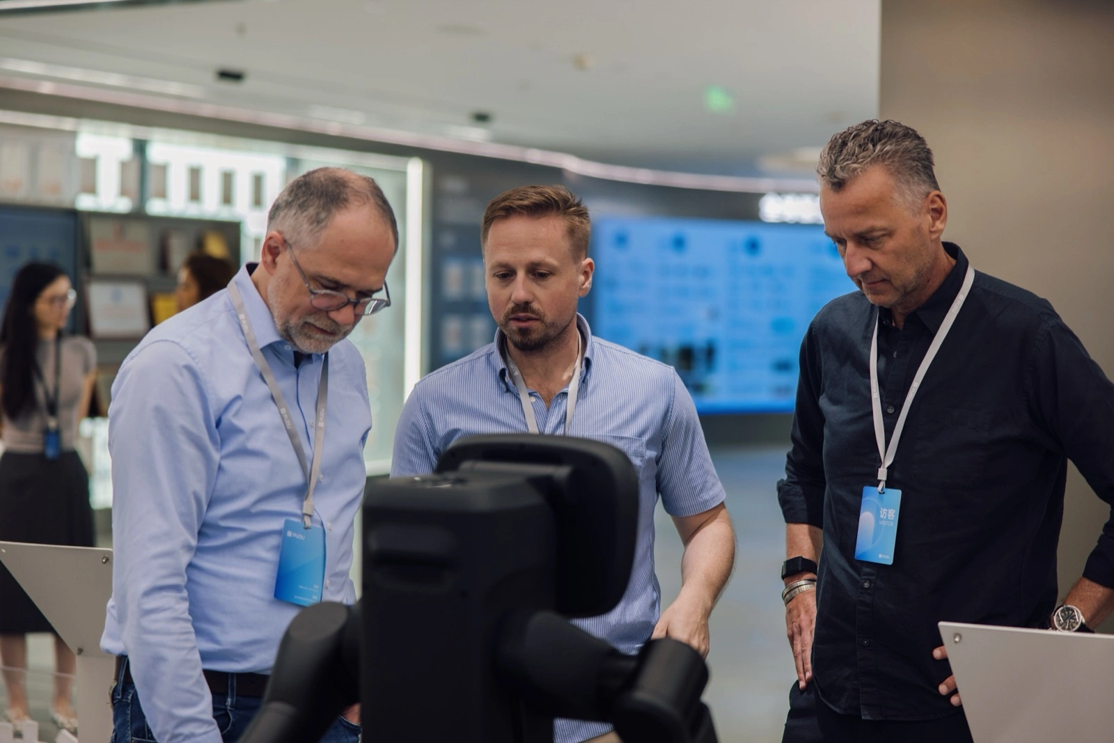 European visitors examining a robot during an Asiabits company visit