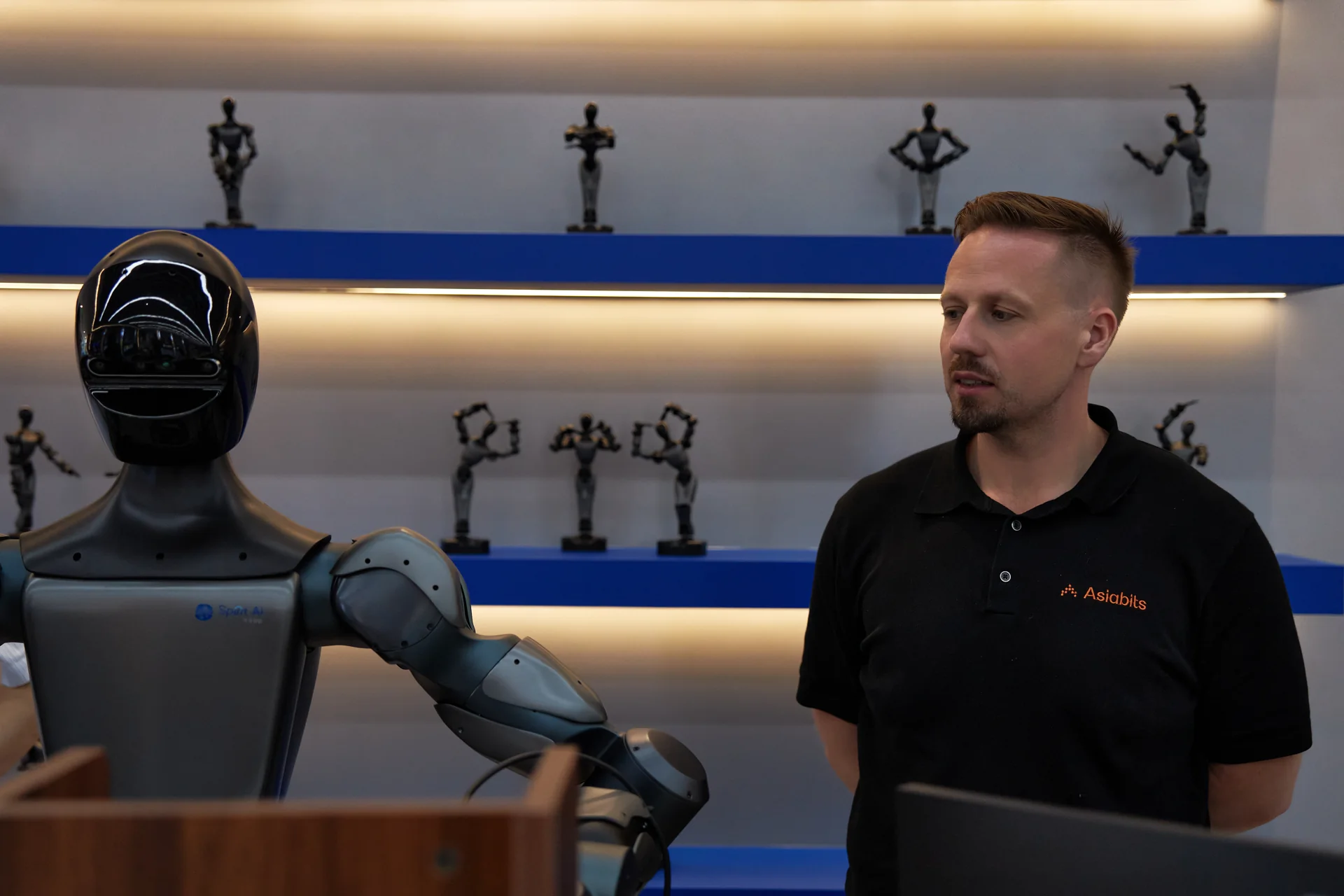 Thomas Derksen beside a Spirit AI humanoid in a showroom
